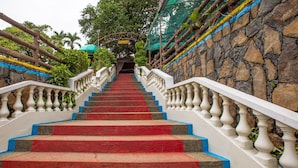 A staircase with red steps, white balustrades, and a stone wall. - OYO 588 Sunrock Resort (Antipolo)