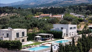 Eine moderne Villa mit Swimmingpool, Außenbereich und Blick auf die umliegende Landschaft.