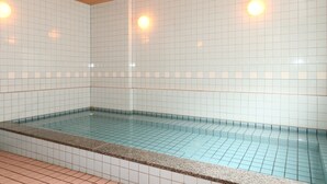 Una piscina con paredes de azulejos y techo de madera.