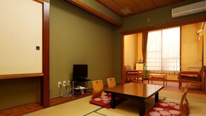 Um quarto em estilo japonês tradicional, com tatames, uma mesa baixa e mobiliário de madeira.