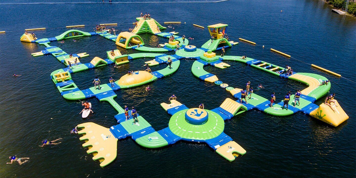 An aerial view of a water park with various inflatable play structures and slides.