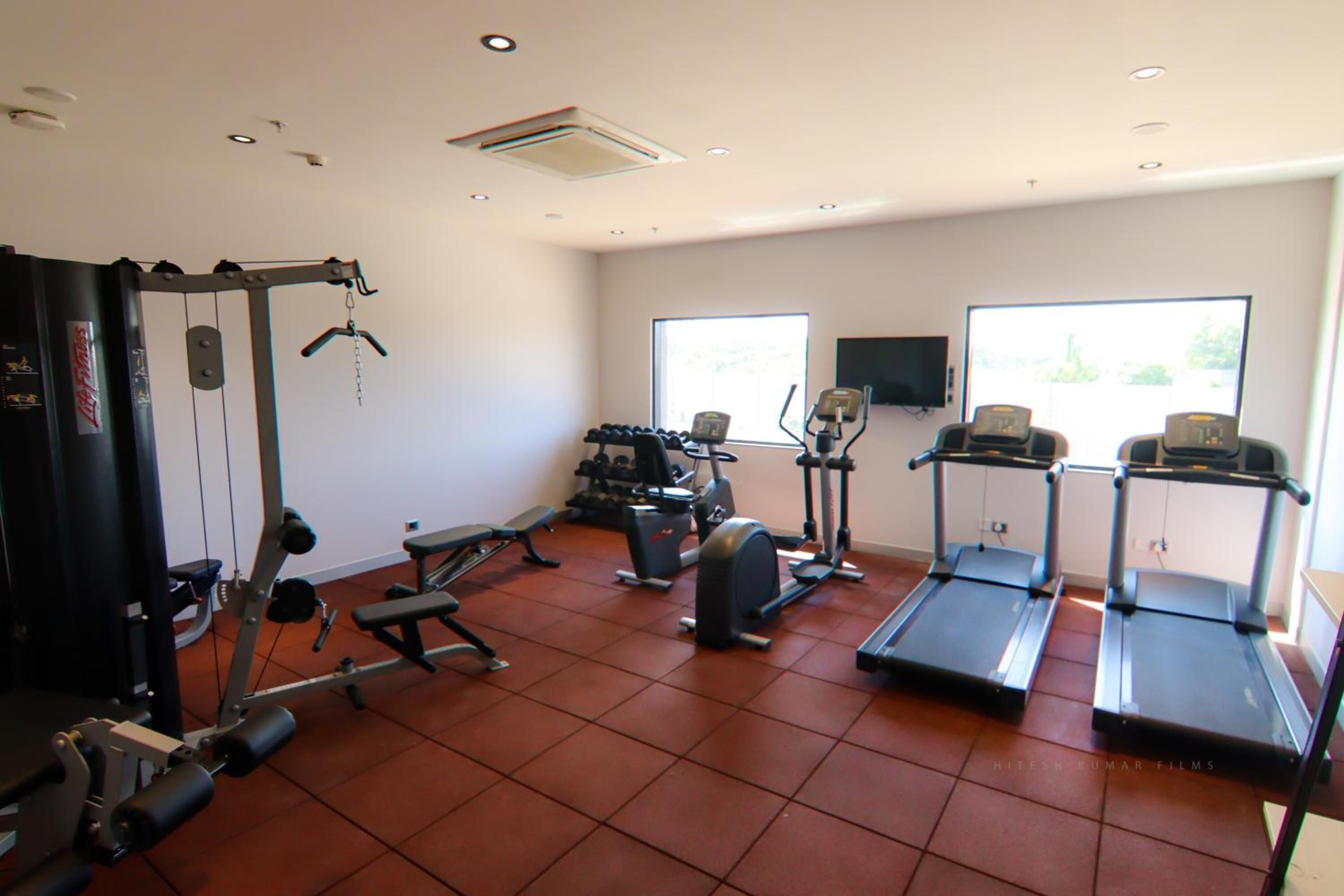 Un gimnàs amb cintes de córrer, aparells de musculació i equipament cardiovascular.