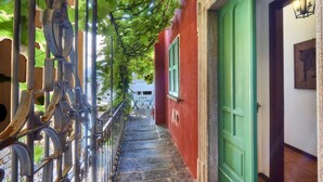 A narrow stone staircase with metal railings and a green door. - Casa Pergola on the lakeshore (Varenna)