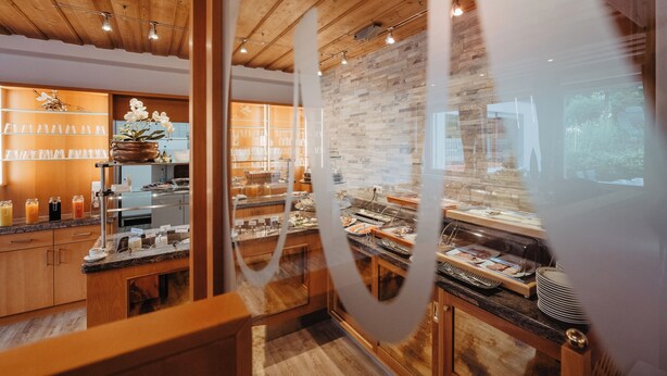 A breakfast buffet with a variety of food items and a wooden interior design. - Pension- Hotel Maximilian (Bad Fuessing)