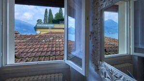 A room with a view of a restaurant named "Ristorante Terrazza" and a mountain landscape. - Wonderful Casa Veranda (Varenna)
