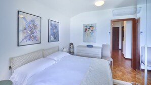 A bedroom with a bed, a dresser, and wall art. - Wonderful Casa Veranda (Varenna)