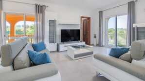 A modern living room with a flat-screen TV, two sofas, and a coffee table. - Casa Carmo - Villa with private pool, billiards and table tennis. (Carvoeiro)