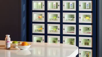 Una cocina moderna con encimera blanca, taburetes y una exposición de alimentos en la pared.