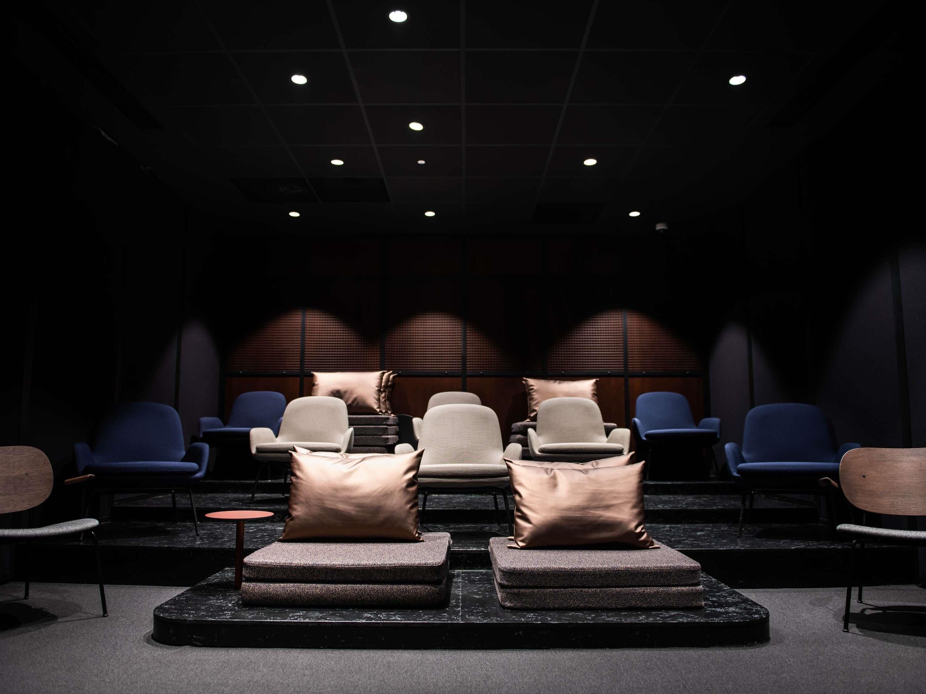 Una sala oscura con filas de asientos y una zona de escenario.