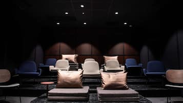 A dark room with rows of seating and a stage area.
