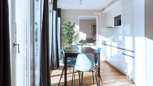 Una cocina moderna con armarios blancos y una campana extractora de acero inoxidable.