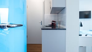 Una cocina moderna con estufa integrada, un lavamanos pequeño y un microondas.