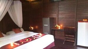 A hotel room with a bed, a desk, a chair, and a television on the wall. - Bali Elephants Boutique Villa (Jimbaran)