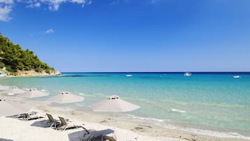 Pantai pribadi, kursi berjemur, payung pantai, dan handuk pantai