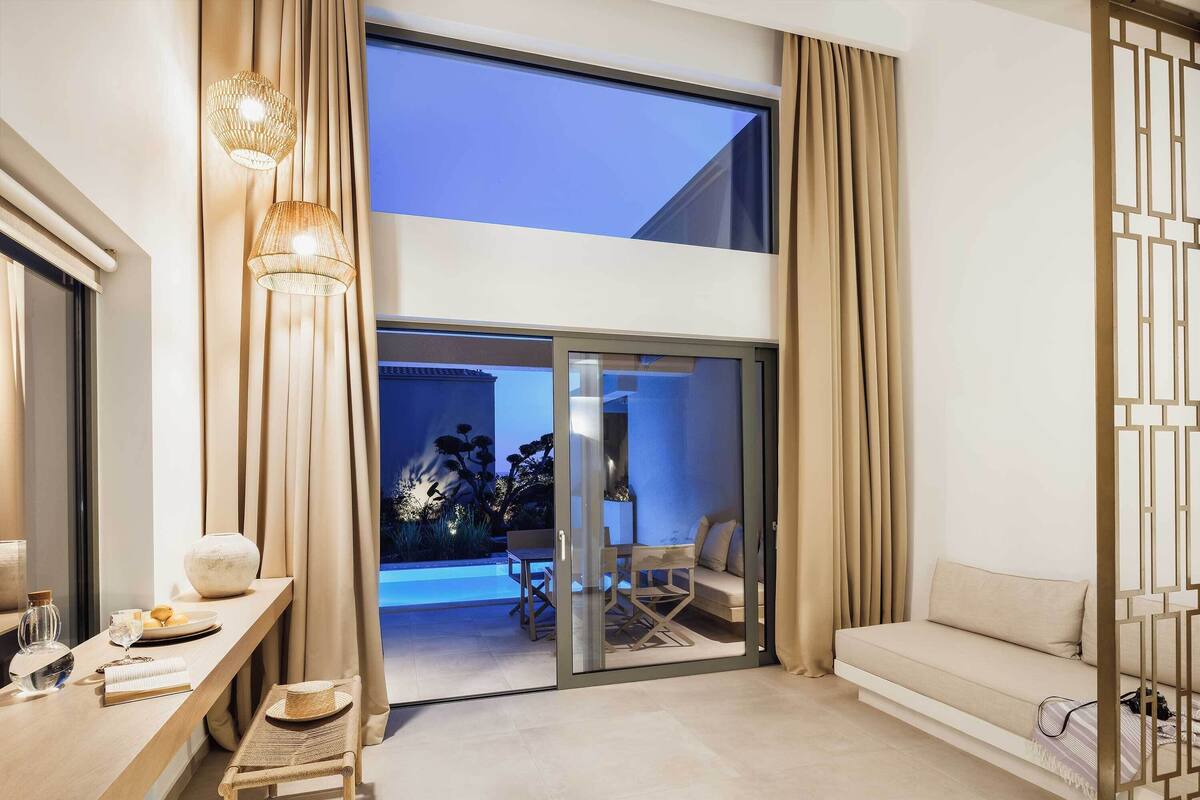 Un salon moderne comprenant un canapé, une table à manger avec des chaises et une porte vitrée donnant sur un balcon.