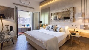 A modern bedroom with a large bed, a wooden ceiling, a wall-mounted mirror, and a small table with a lamp. - Beachfront luxury villa with hot tub & sunset view (Chania)