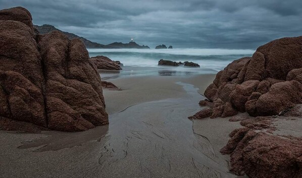 Stunning coastal scenery with rugged rock formations and a sandy beach.