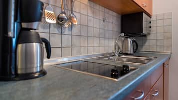 Eine Küche mit Kaffeemaschine, Wasserkocher und Geschirr auf der Arbeitsfläche.
