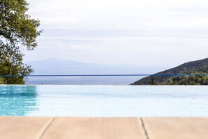 A pool with a view of a distant shoreline and mountains. - Villa Lupara (Salerno)