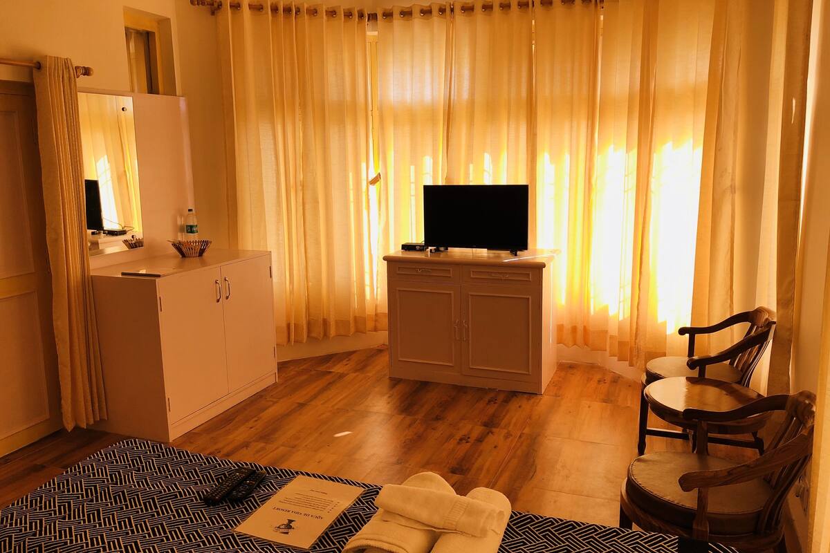 Een hotelkamer met een bed, een bureau, een televisie en een stoel.