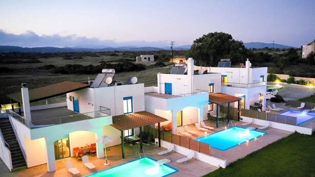 A modern villa with a swimming pool, outdoor seating, and a staircase leading to the upper levels. - Nerida Beachfront Villas (Rhodes)