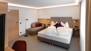 Une chambre d’hôtel avec un lit, un canapé, un bureau et une chaise.