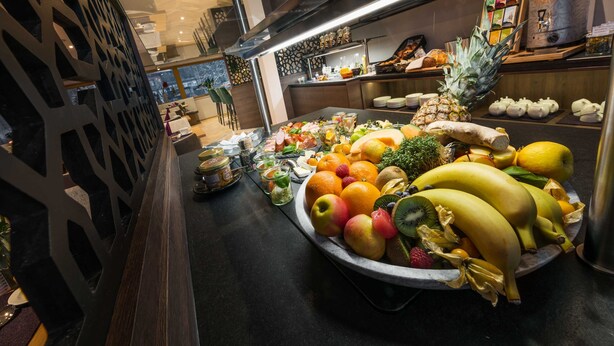 Une présentation de fruits variés, accompagnée d’une machine à café, dans un décor moderne.