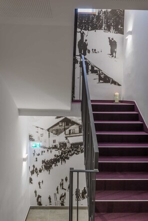 Una escalera con peldaños morados y barandilla negra.