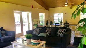 Ein Wohnzimmer mit einer Couch, einem Couchtisch und einem Essbereich mit Tisch und Stühlen.