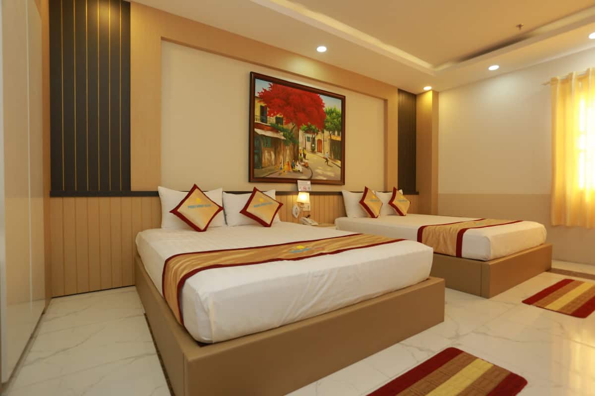 Quarto de hotel com duas camas, um quadro na parede e uma mesa de cabeceira.