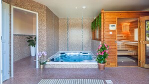 A spa area with a hot tub, tiled walls, wooden doors, and potted plants. - Albizia - Charming gîte in the heart of Perigord - Max 4 people (Nouvelle-Aquitaine)