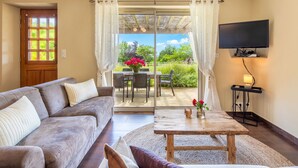 A living room with a sofa, coffee table, and TV. - Albizia - Charming gîte in the heart of Perigord - Max 4 people (Nouvelle-Aquitaine)