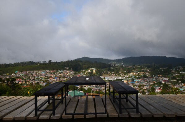 A wooden deck with benches overlooking a town.