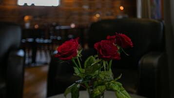 A table with a vase of red roses in a dimly lit indoor setting.