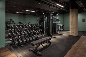 A gym with weightlifting equipment, benches, and dumbbells. - The Gantry London, Curio Collection by Hilton (London)