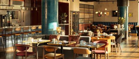 A modern restaurant with high stools, booths, and a bar area.