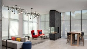 A modern living room with a fireplace, large windows, and contemporary furniture.