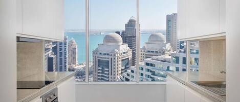 A modern kitchen with a large window overlooking a cityscape.
