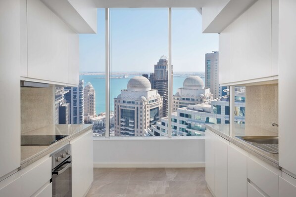 A modern kitchen with a large window overlooking a cityscape.