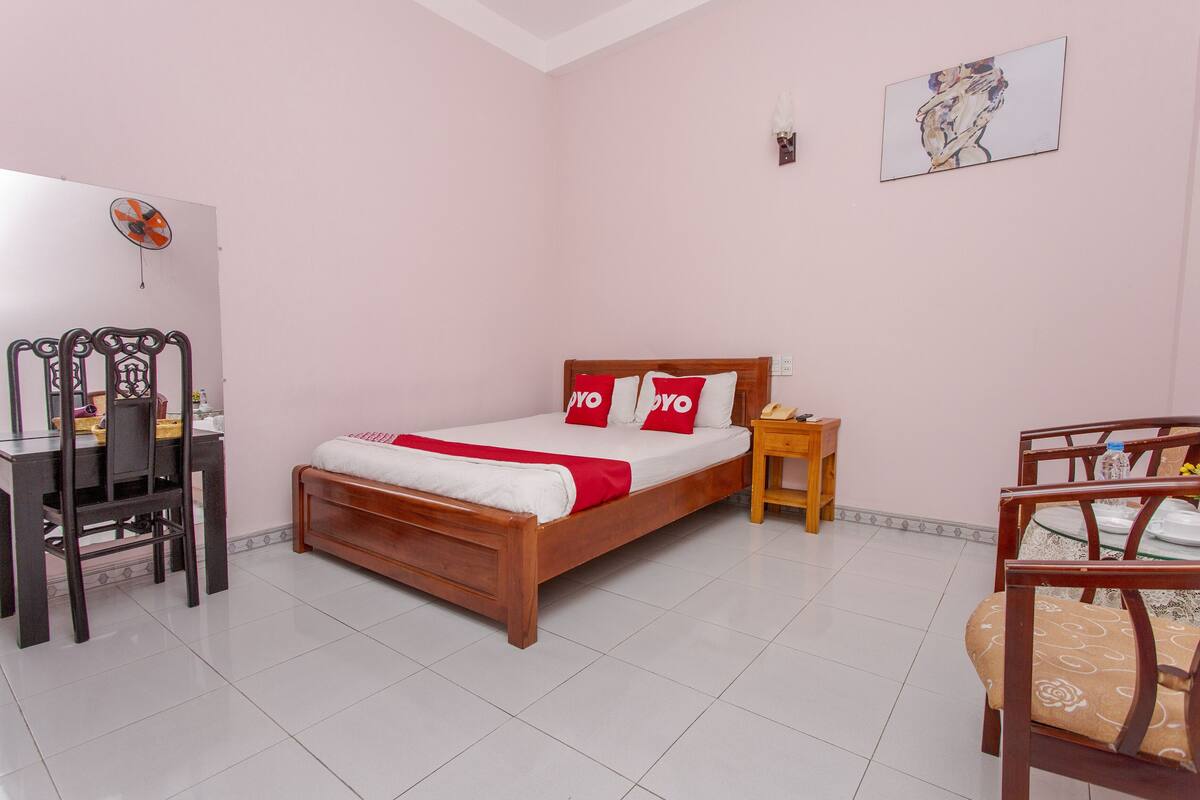 Un dormitorio con una cama de madera, un escritorio y una silla.