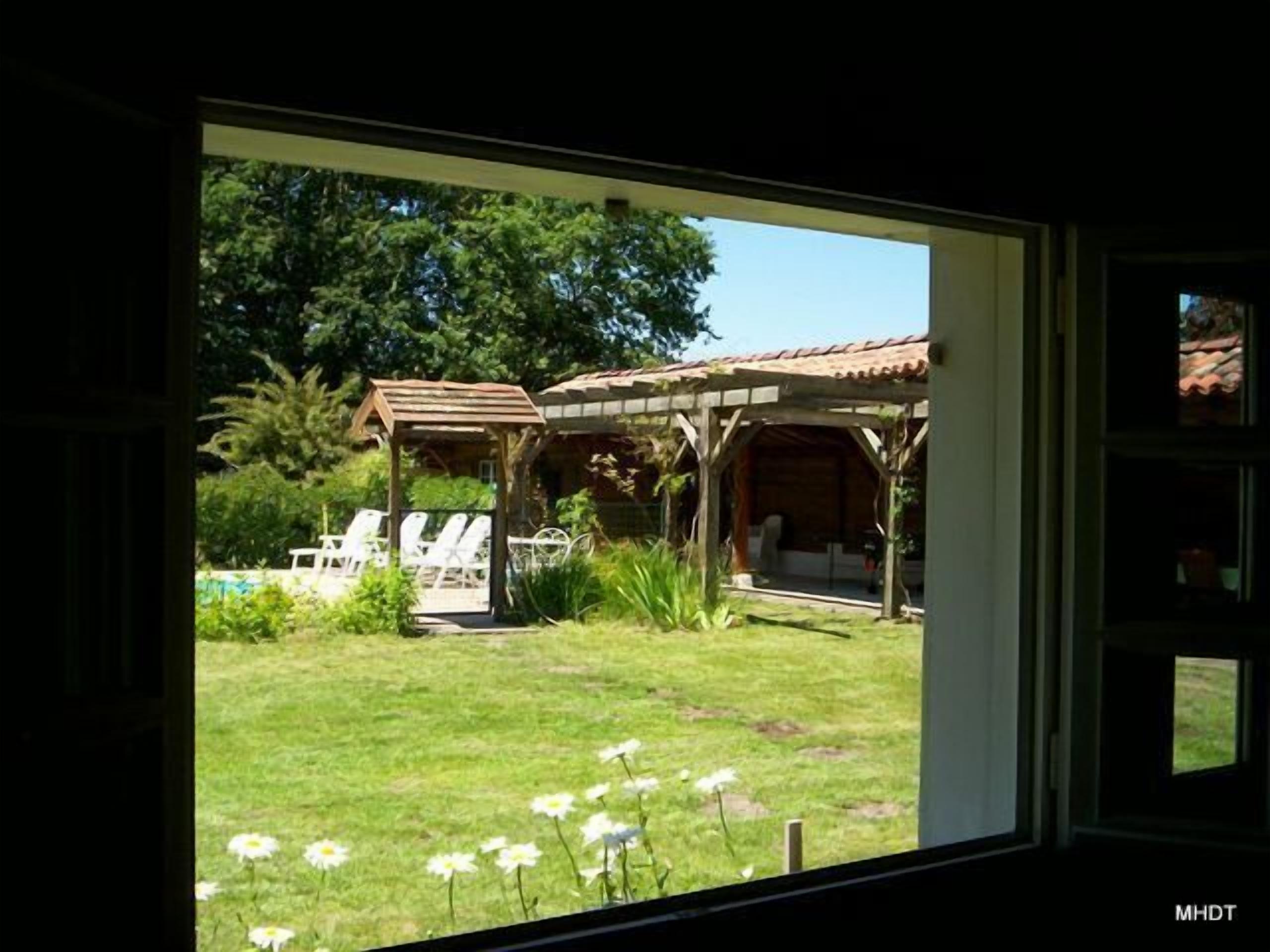 Préau et pergola dans le prolongement de la piscine