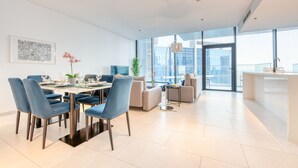 Un soggiorno moderno con zona pranzo, ampie finestre e vista sulla città.
