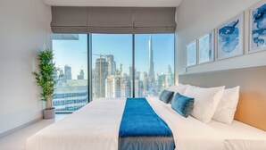 Una camera da letto moderna con un grande letto, vista sulla città e opere d'arte appese alla parete.