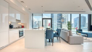Un soggiorno moderno con cucina, zona pranzo e area salotto con vista sulla città.