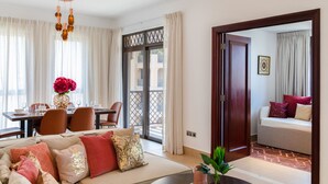 A modern living room with a sofa, dining table, and a balcony view. - Maison Privee - Luxury Living Next to Dubai Mall & Burj Khalifa (Dubai)