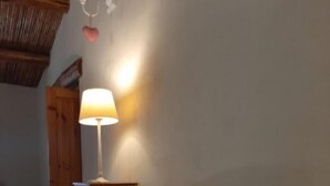 Et soveværelse med en seng, et natbord, en lampe og en trædør.