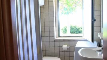 Un bagno piccolo con il water, lavandino e finestra.