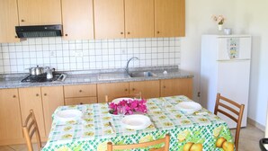 Una cocina con armarios de madera, encimera de granito, fregadero y refrigerador.
