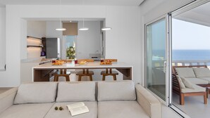 Une cuisine moderne dotée d’un îlot central, de tabourets de bar en bois et de luminaires suspendus.