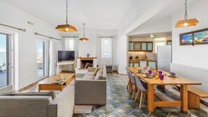 Un vaste espace de vie comprenant un canapé, une table à manger et une cuisine en arrière-plan.